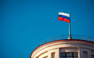 Ruská národní vlajka mává na budově v Petrohradu pod jasnou oblohou.