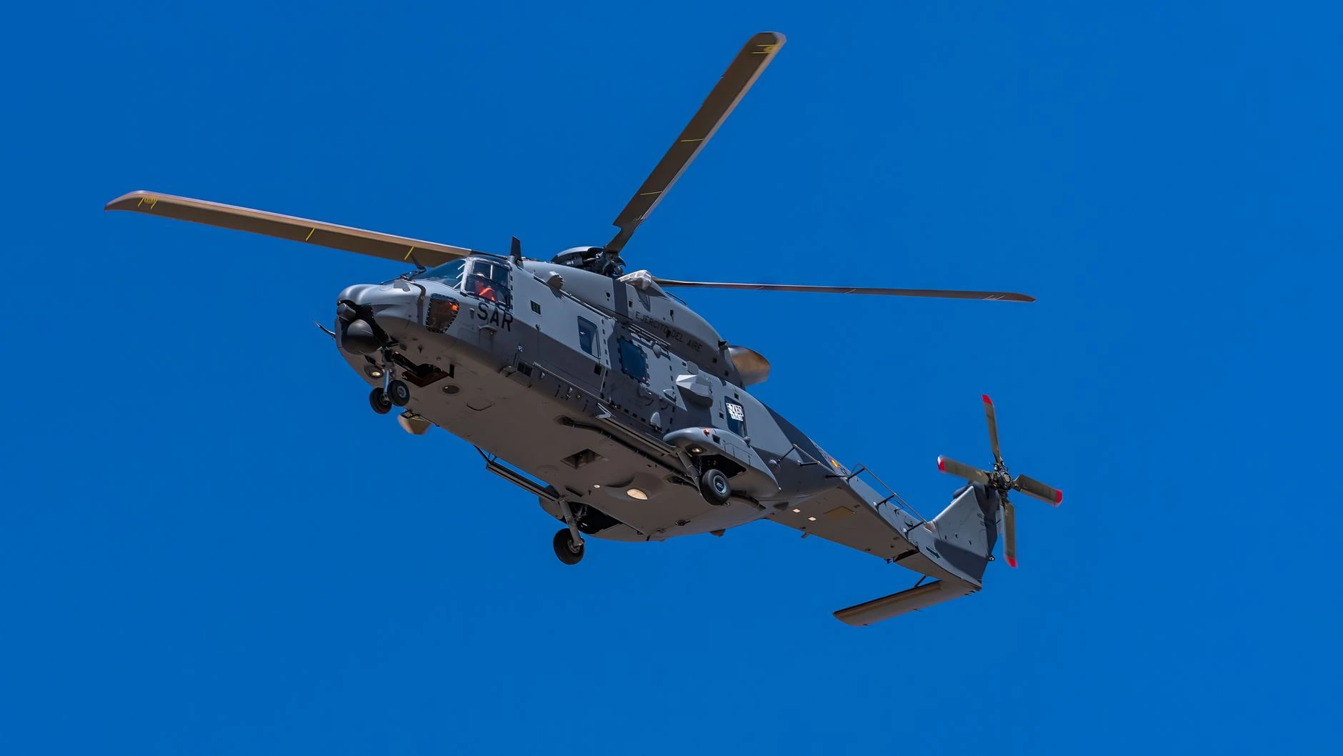 Vrtulník NH90 letící proti jasné modré obloze v Kastilii-La Mancha ve Španělsku.