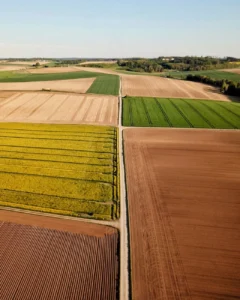 Živý letecký snímek různorodých vzorů zemědělské půdy ve Wallersdorfu, Německo.