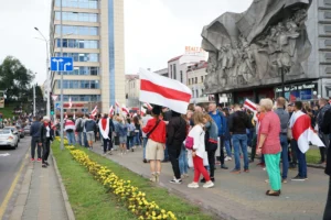 Dav se shromažďuje na protestu v centru Minsku, Bělorusko, s vlajkami a demonstruje pokojně.
